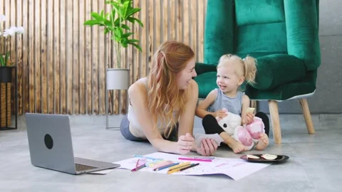 Engaging art activity between mother and daughter at home in a cozy living room Stock Footage 308489495