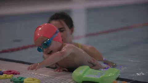 Engaging Child Swimming Lessons with an Instructor at the Local Community Pool Video stock 312435739