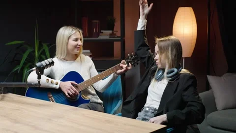 Engaging conversation in a studio podcast with guitar melodies Video stock 304422983