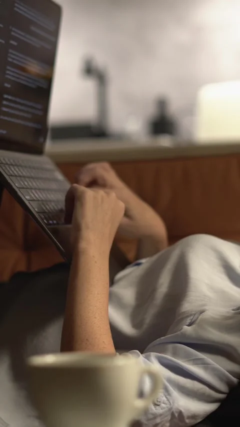 Engaging in a Cozy LateNight Work Session at Home, comfortably seated with my Stock Footage 293147327