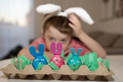 Engaging in Creative Easter Egg Decoration with Adorable Bunny Ears for added Stock Photos