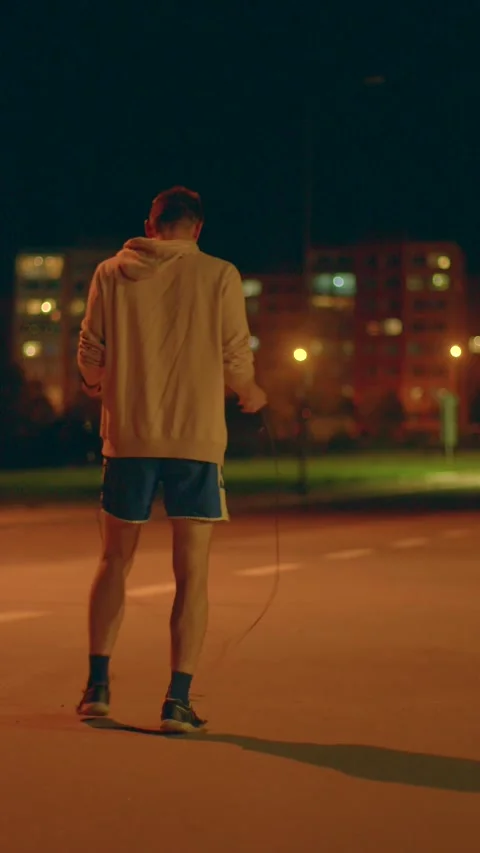 Engaging in dedicated workout during midnight hours on peaceful urban pathways Stock Footage 324592557
