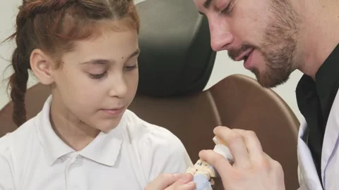 Engaging doctor explains jaw structure to an inquisitive girl Stock Footage 311946685