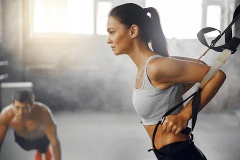 Engaging in Dynamic Fitness Training using Suspension Equipment inside a Workout Stock Photos