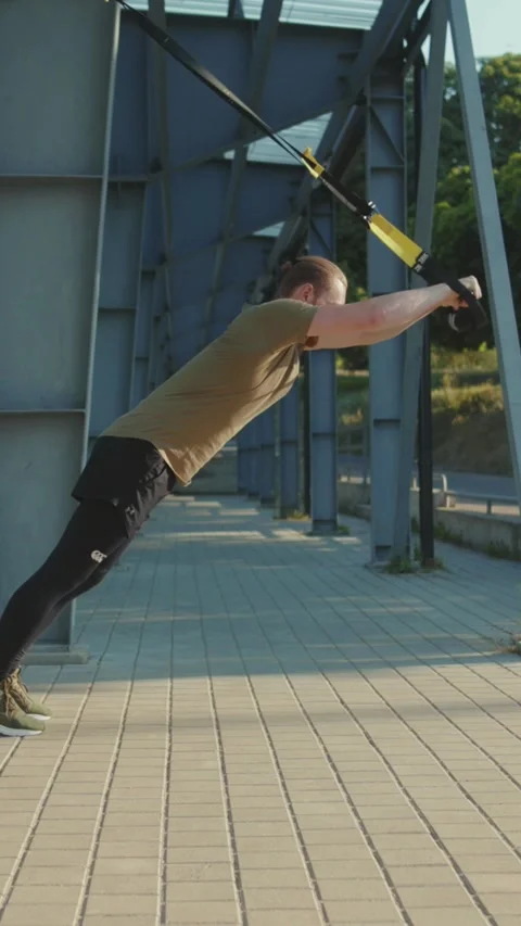 Engaging in a Dynamic Outdoor Workout featuring Resistance Bands for enhanced Stock Footage 305878297