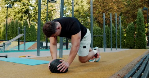 Engaging in a Dynamic Outdoor Workout utilizing a Medicine Ball for Stock Footage 317980161