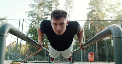 Engaging in the dynamic pushup exercise on parallel bars requires strength Stock Footage 317837845