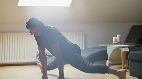 Engaging in Dynamic Stretching Exercises within the Comfort of a Home Stock Footage 308663595
