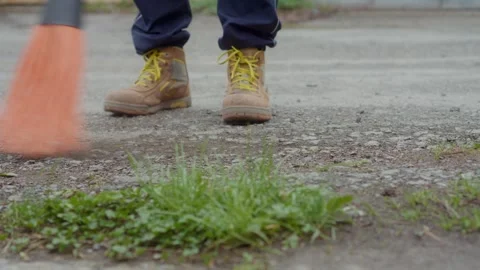 Engaging in Gardening Activities While Wearing Work Boots and Using a Rake on Stock Footage 308740098