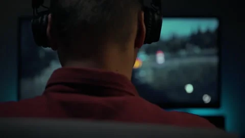 Engaging in an immersive gaming experience at home in the evening Stock Footage 303661851