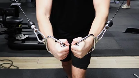 Engaging in intense cable exercises for upper body strength in a gym setting Stock-Footage 295280368