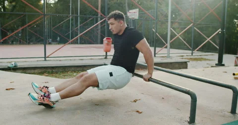 Engaging in an Intense Workout Session Utilizing Parallel Bars at the Park Stock Footage 317837586