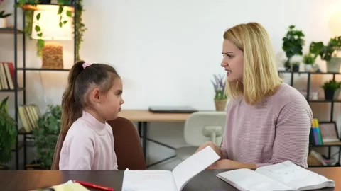 Engaging moments of learning and communication between a child and her mentor in Stock Footage 303755259