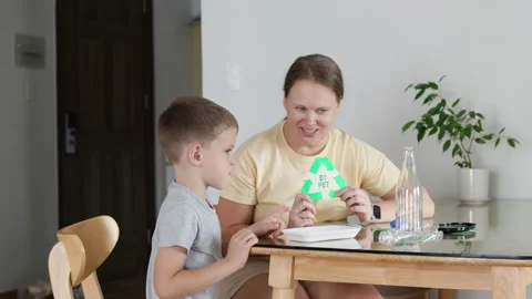 Engaging mother and son teach valuable recycling lessons at home. Video stock 293555327