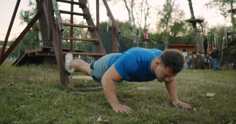 Engaging in an Outdoor PushUp Workout Using Playground Equipment is a great Stock Footage 317980723