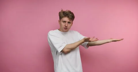 Engaging performer showcases fun hand gestures against a bright pink backgr.. Stock Footage 317327978