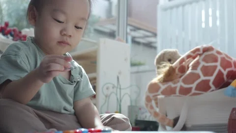 Engaging Playtime: Child Exploring Creativity with Colorful Toys Video stock 344032140