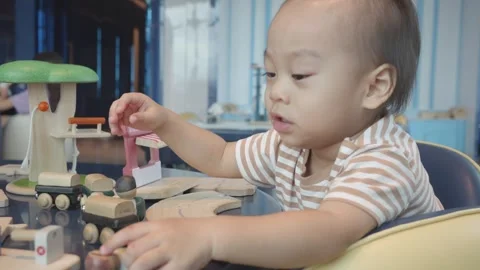 Engaging Playtime: Child Exploring Wooden Toys Vidéo 343556372