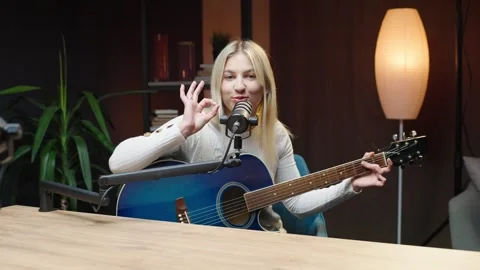 Engaging podcast session featuring a female host playing guitar in studio Video stock 315909321