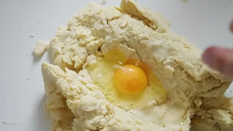 Engaging in the process of preparing fresh dough using eggs and flour right in Video stock 314468031