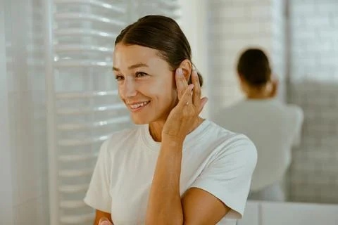 Engaging in a SelfCare Routine within a Bright and Inviting Bathroom Atmosphere Stock Photos