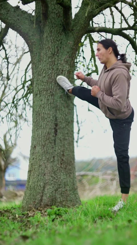 Engaging in Stretching Exercises Beneath the Shade of a Tree in the Beautiful Stock Footage 302659062