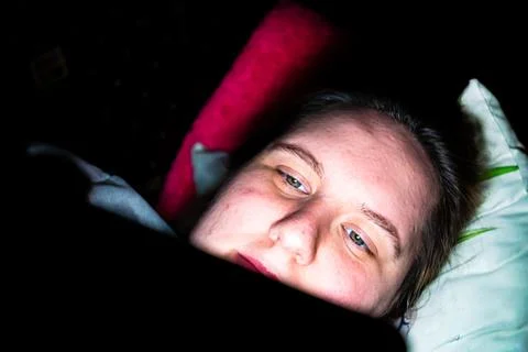 Engaging with technology during a quiet night at home in a cozy setting Stock Photos