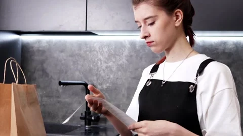Engaging in thoughtful budgeting while reviewing a shopping receipt Stock-Footage 296315274