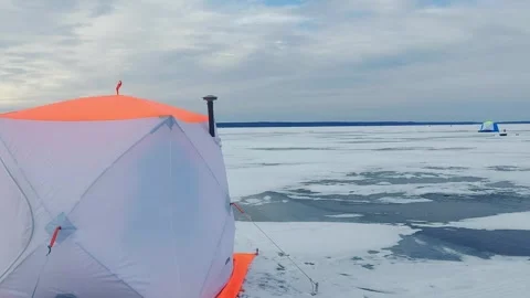 Engaging in the unique experience of ice fishing on a frozen lake during the win Stock Footage 342581508