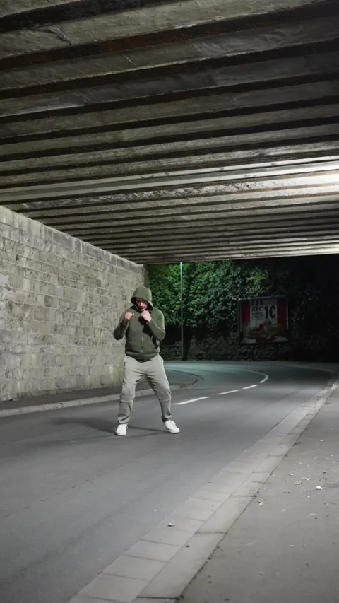 Engaging in Urban Night Boxing Training Under an Underpass with Dynamic Energy Stock Footage 307177788