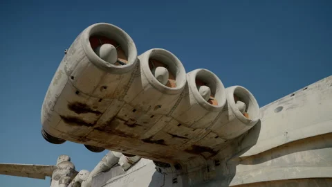 The engine of an abandoned ekranoplane is gray against a bright blue sky, smooth Stock Footage 256012867