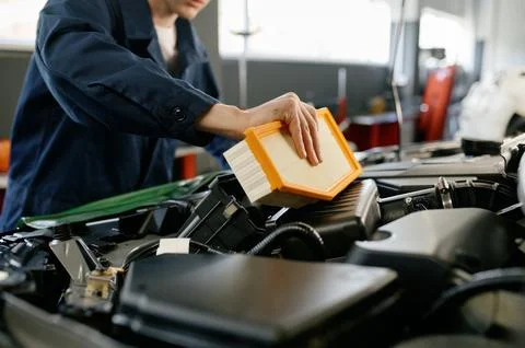 Engine air filter replacement concept, closeup shot of auto mechanic at work Stock Photos