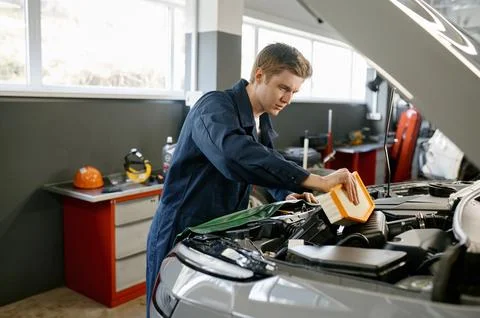 Engine air filter replacement concept, auto mechanic at work Stock Photos