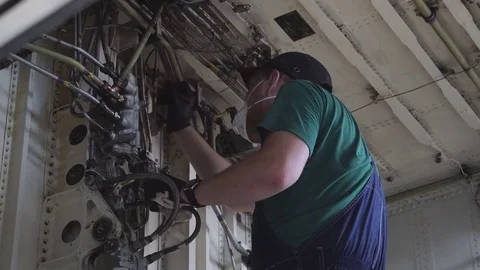 Engine and chassis of the passenger airplane under heavy maintenance. Engineer Stock Footage 84395528