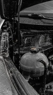 Engine and engine compartment of a car during washing. foam applied. car wash Foto stock