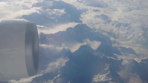 Engine of big jet airplane flying over swiss alps mountains Stock Footage 279835747