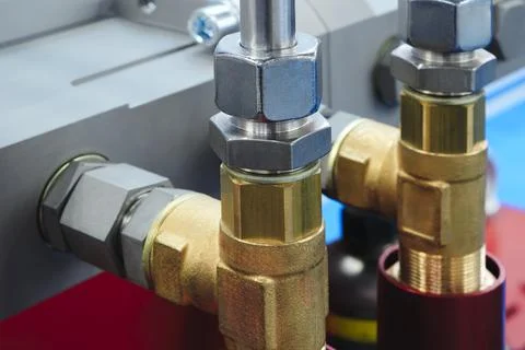 Engine block centers a black pump. Interconnected metal pipes link brass valv Stock Photos