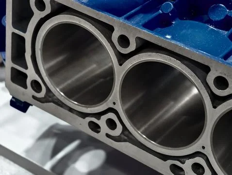 Engine block showcasing precision engineering with three cylindrical chambers 库存照片