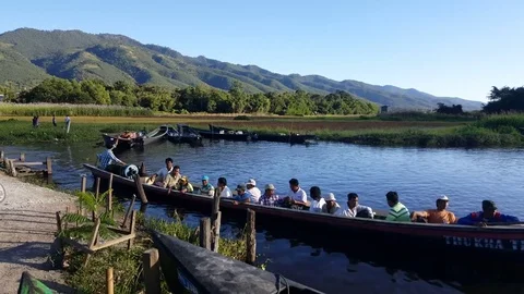 Engine boat full with passengers leaves dock, hills in background, Inle Lake 스톡 동영상 79971564