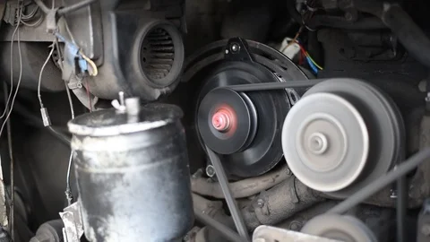The engine of the car, in a running car, the movement of the belt pulley compres Stock Footage 110827248