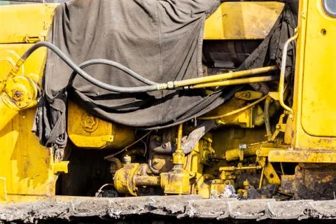 The engine compartment of the caterpillar tractor is covered with an oiled te Stock Photos