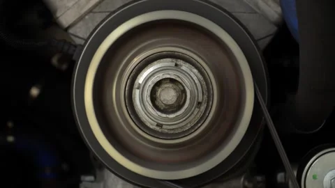 An engine gear connected to a belt turns quickly Stock Footage 314736103