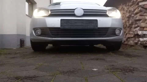 Engine ignition sound from front view of stationary car with headlights on Stock Footage 322575965