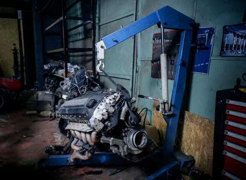 Engine instalation on blue crane hook on car repair service Foto stock