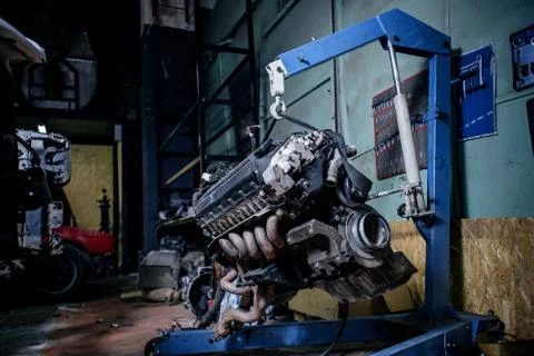 Engine instalation on blue crane hook on car repair service Foto stock
