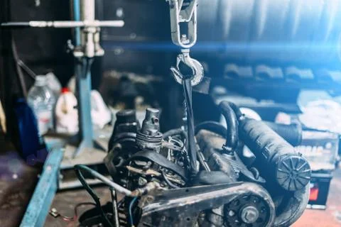 Engine instalation on crane hook on car repair service Stock Photos