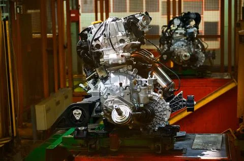 Engine installing in car compartment in assembling workshop Stock Photos