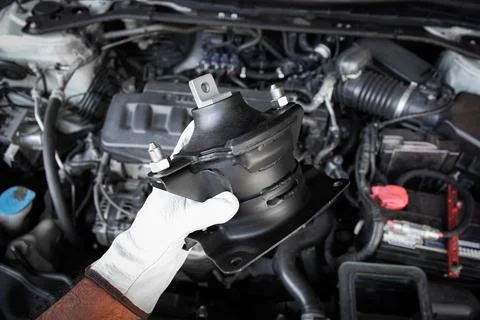 Engine mount component held in auto mechanic hand Stock Photos