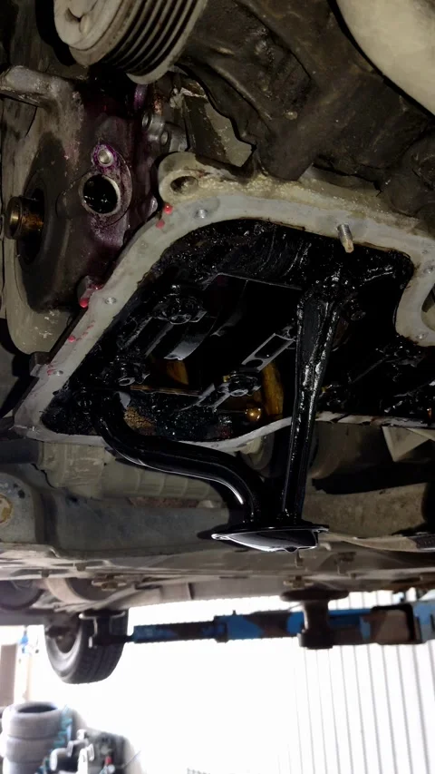 Engine oil pan removed showing oil pickup tube with sludge Stock Footage 334321577