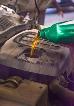 Engine oil poured into car engine Stock Photos